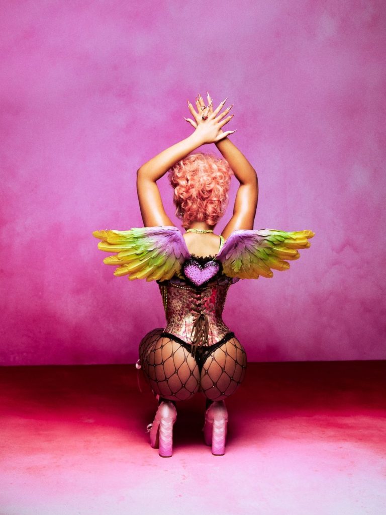 Megan Thee Stallion sit on her knees and posing with her back to the camera