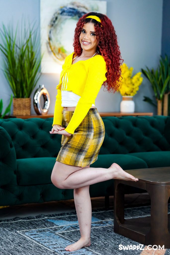 Full body view of pretty girl in preppy outfit lifting one of her legs