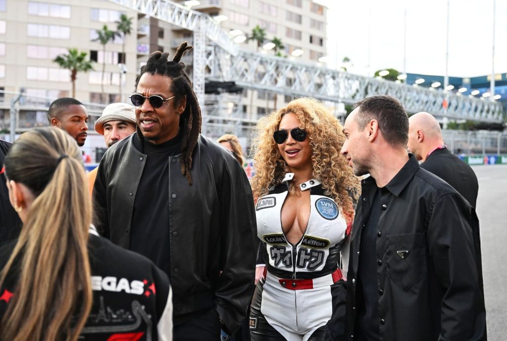 Horizontal full close up of Beyonce and Jay-Z among a group of people
