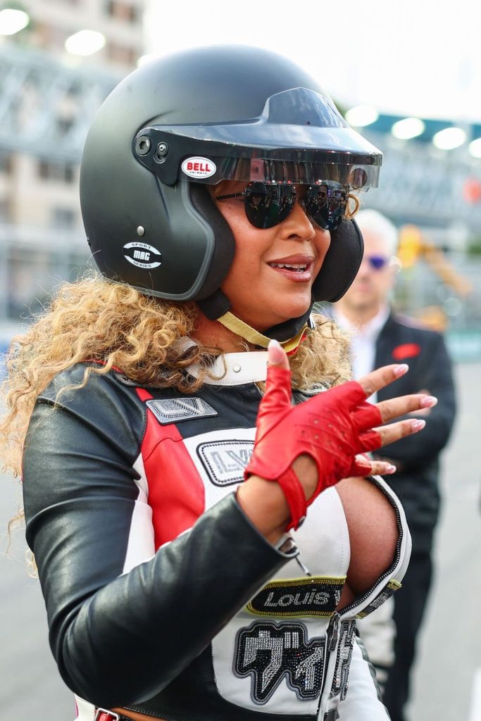 Close up side view of Beyonce wearing a racing outfit and helmet