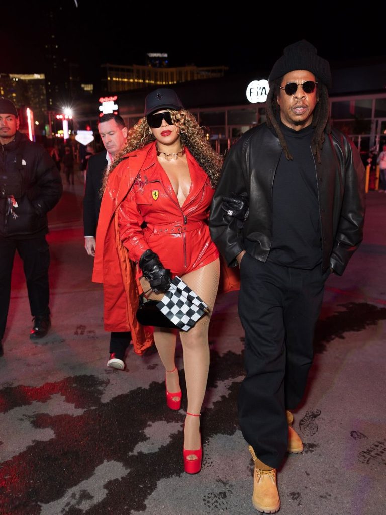 Full body view of Beyonce and Jay-Z walking across a parking lot