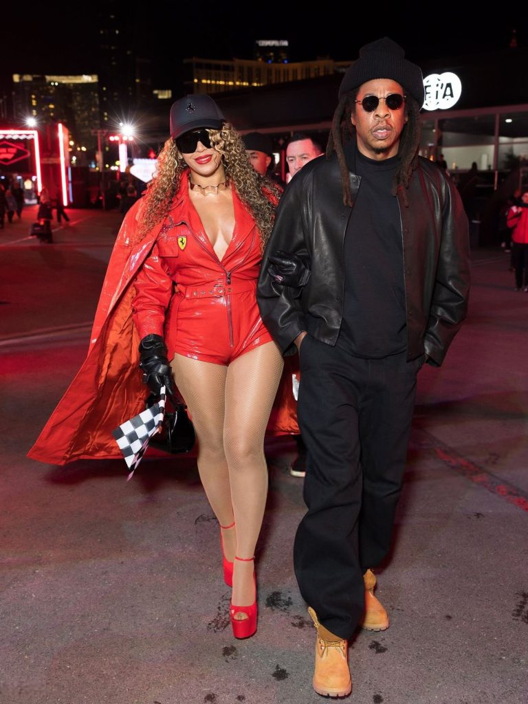 Full body view of Beyonce and Jay-Z walking across a parking lot
