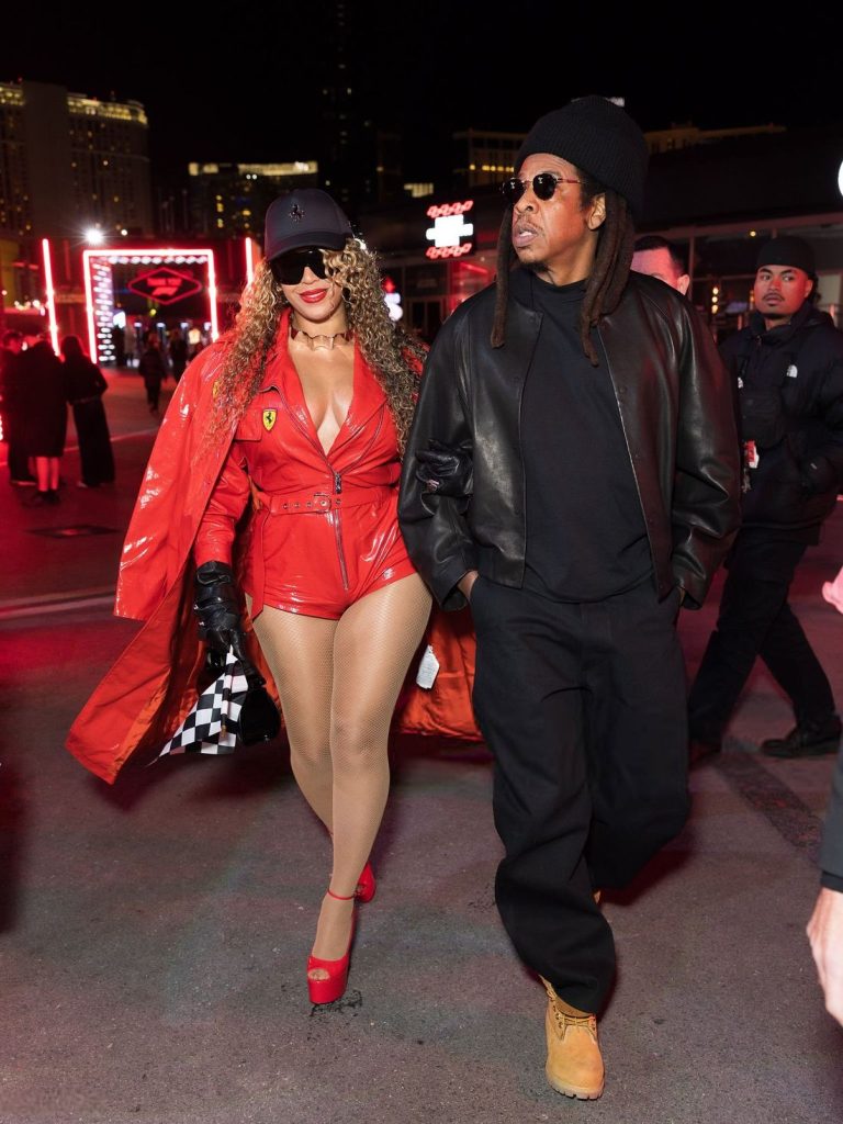 Full body view of Beyonce and Jay-Z walking across a parking lot