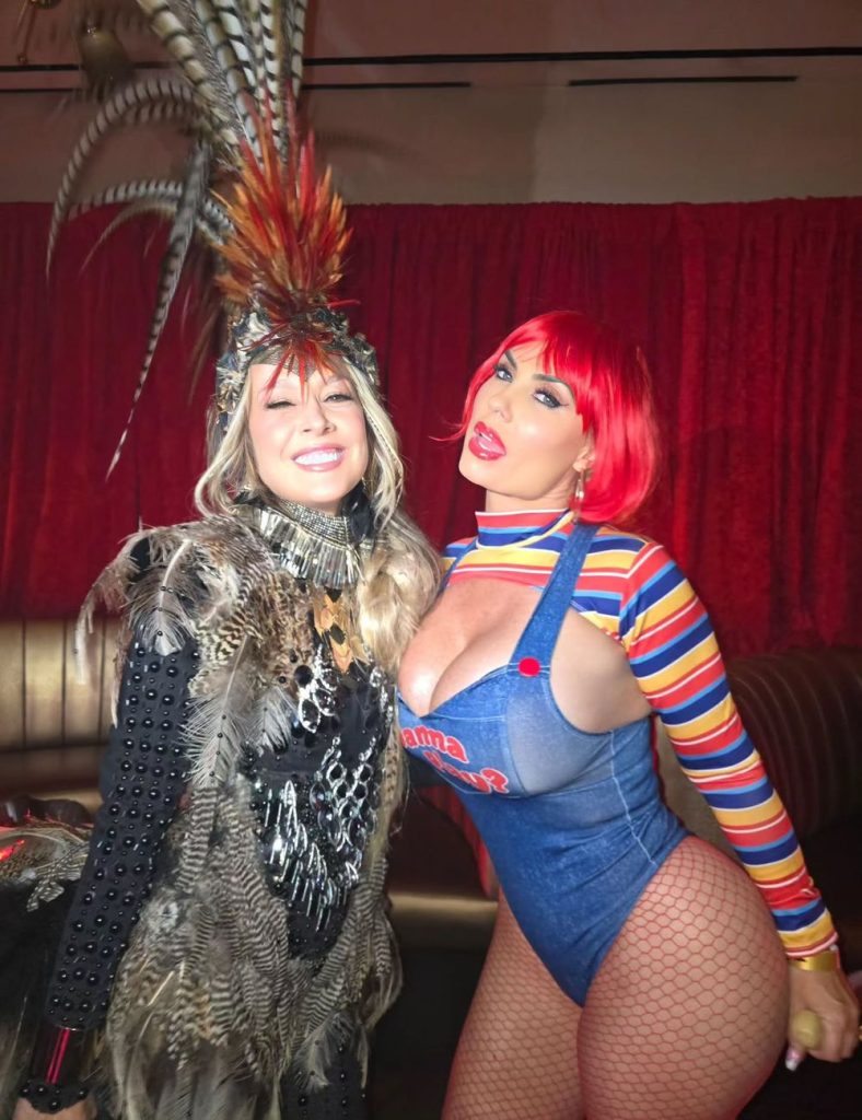 Frontal view of two women striking a pose together in their Halloween costumes