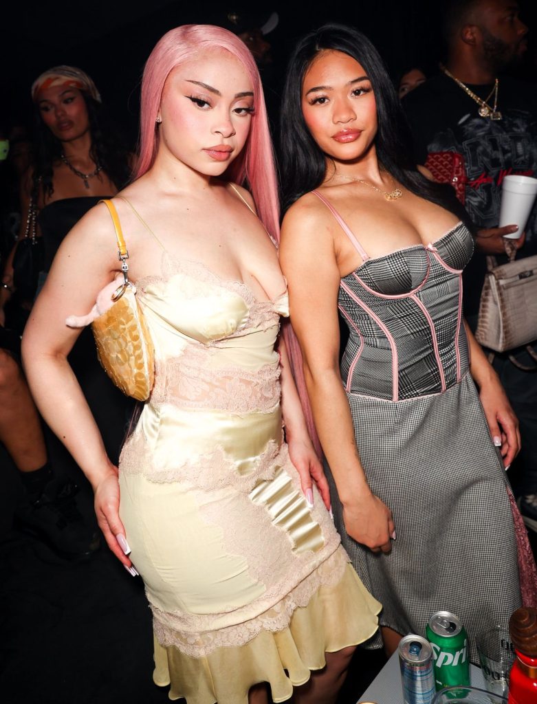 Frontal view of Ice Spice posing next to an Asian girl at a party