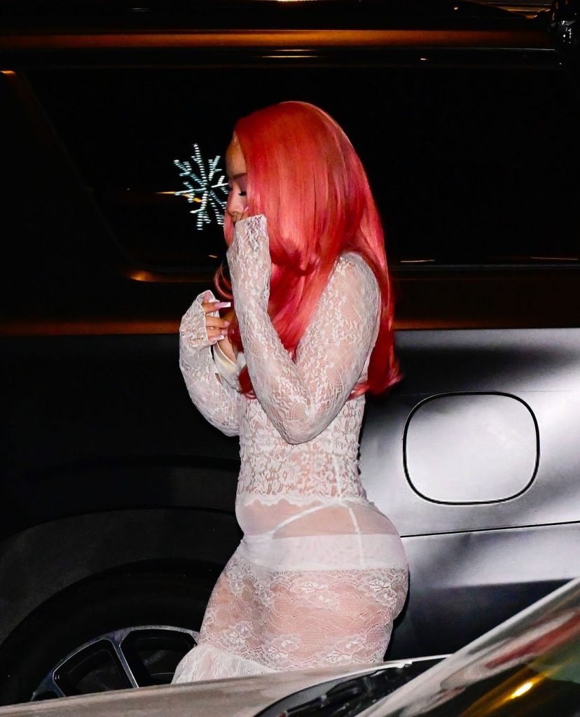 Side view of Ice Spice walking between cars