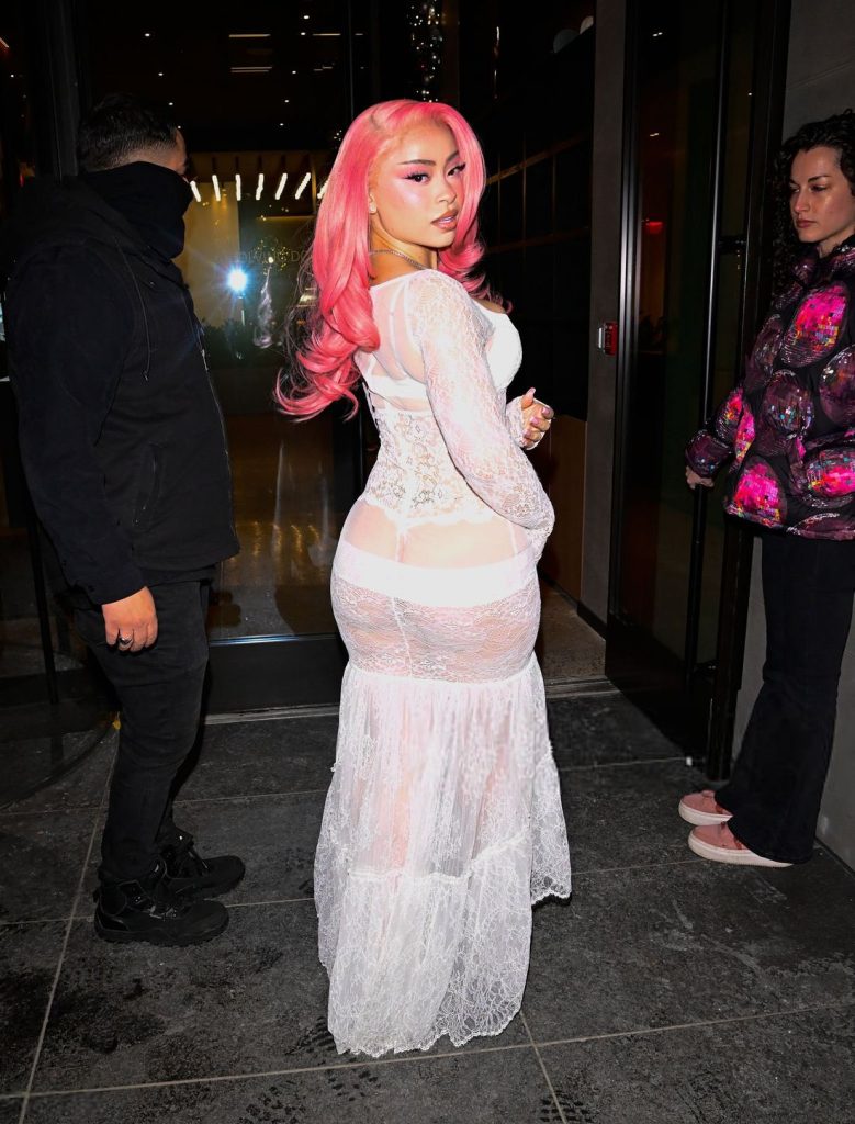 Closer backside view of Ice Spice looking back while posing on a sidewalk