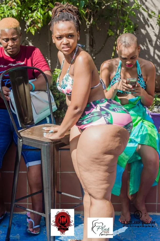 Full body side view of a black woman in a bikini having very thick legs at a backyard party