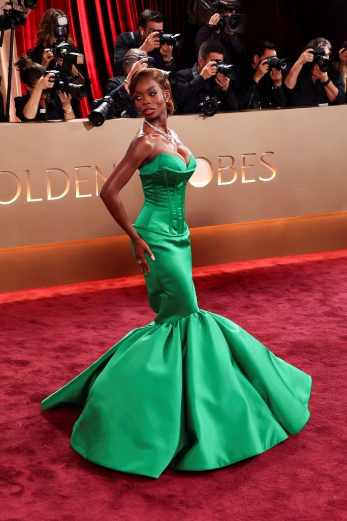 Full body side view of black woman looking back on a red carpet