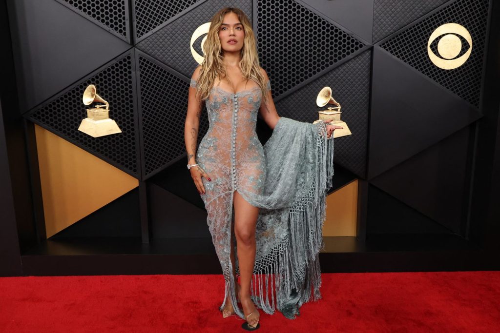 Far away frontal view of Karol G lifting up her dress