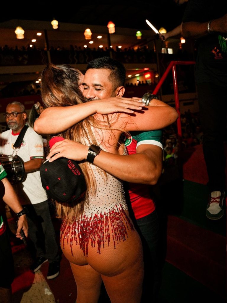 Brazilian woman in a bodysuit hugging a man