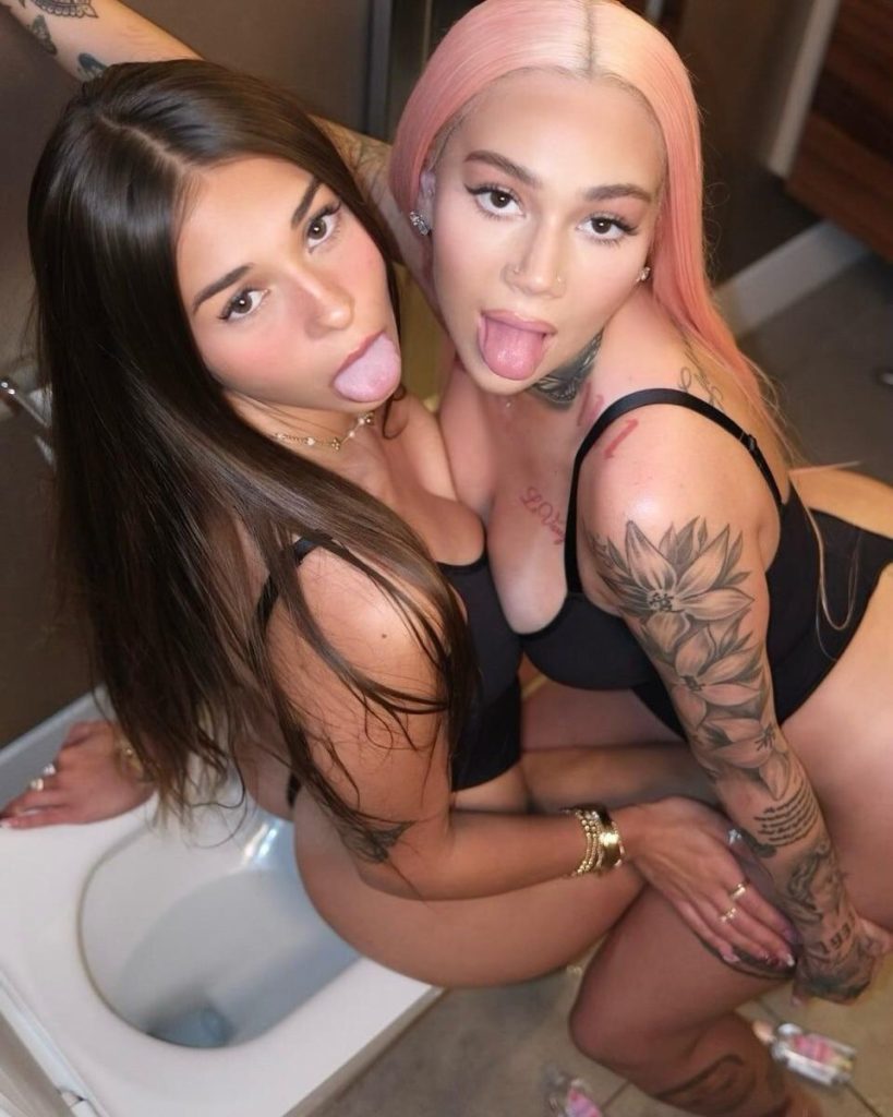 Two women posing in swimsuits posing close together and sticking their tongues out
