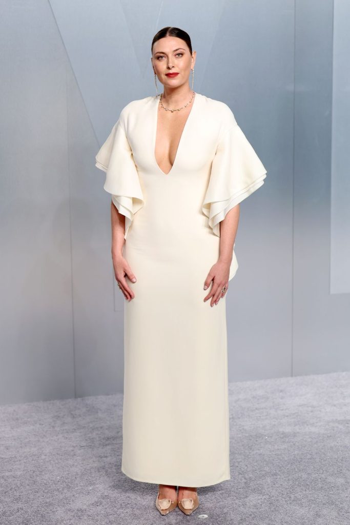 Elegant woman standing in a white gown.