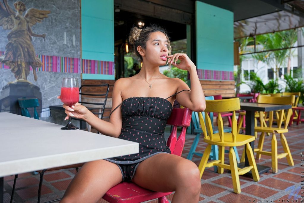 Woman sitting with a drink on a café patio