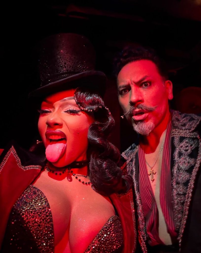 Megan Thee Stallion sticks her tongue out when taking a close up selfie with a man wearing makeup.