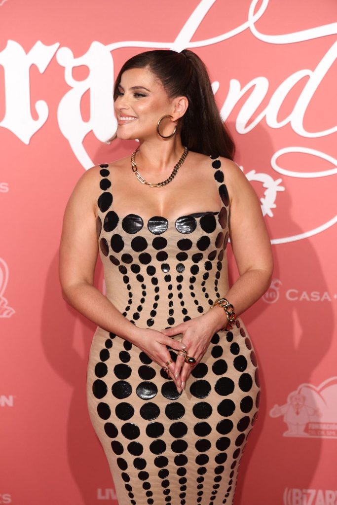 Thick Nelly Furtado in tight dress smiling on a red carpet.