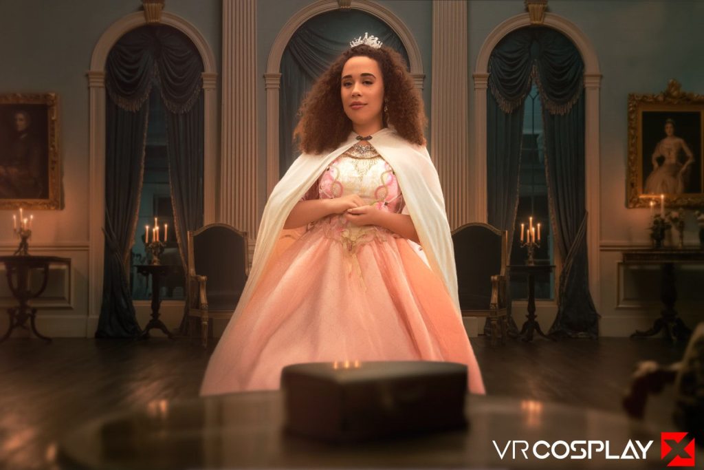 A woman in a pink ballgown and white cape stands in an elegant, candle-lit room, wearing a tiara. The room features classical decor and framed portraits.